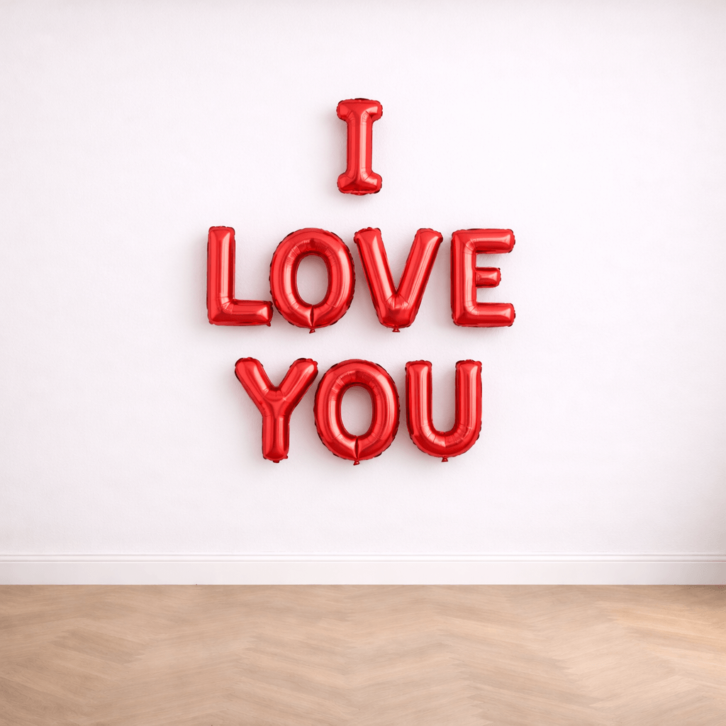 Red I Love You foil letter balloons on a plain white wall