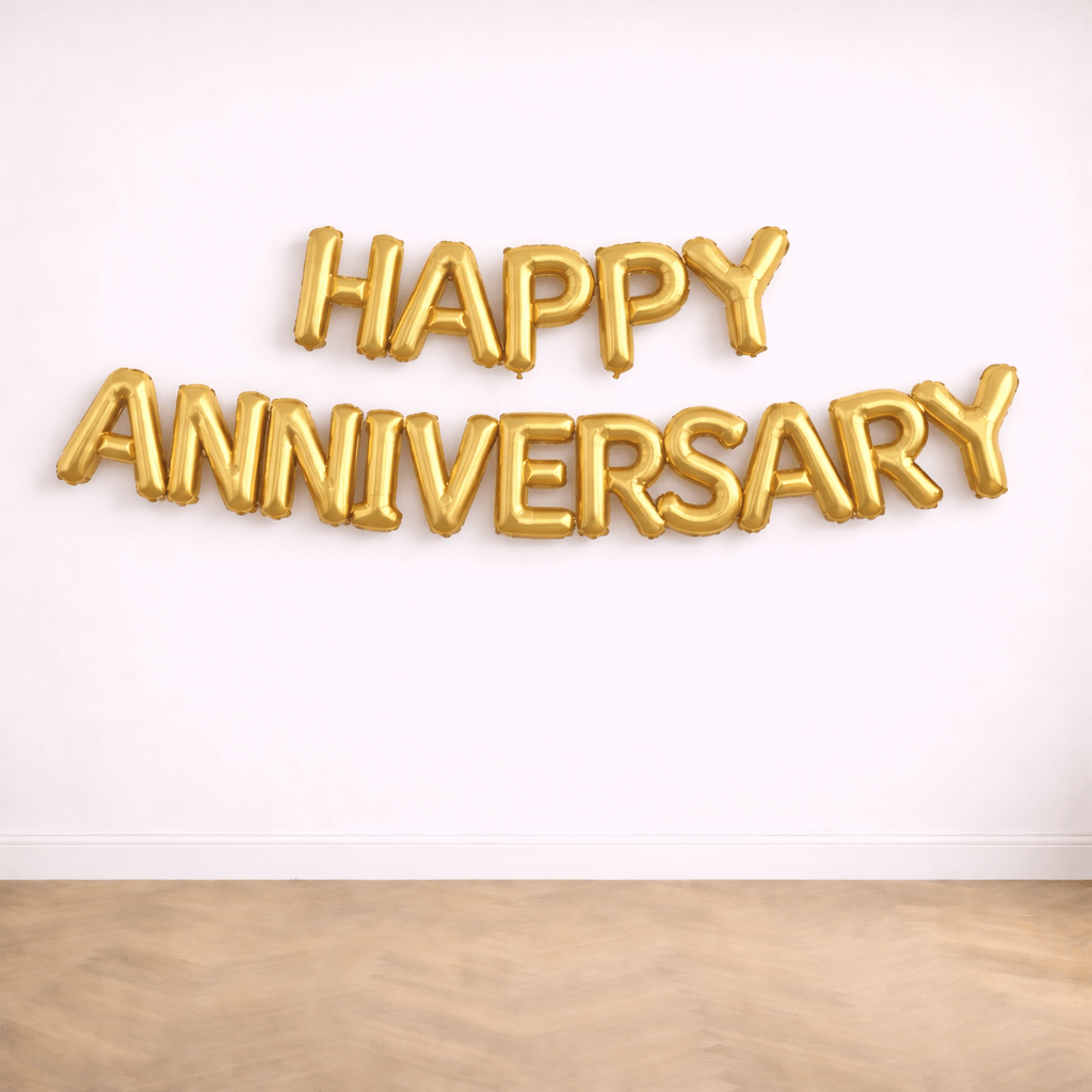 Gold Happy Anniversary foil letter balloons against a white wall