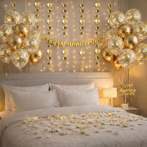 Decorated bedroom with gold balloons, 'Happy Anniversary' sign, and fairy lights.